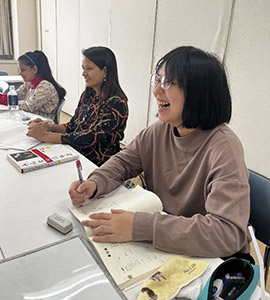 Learning Japanese. She appears to be enjoying the class with Mitu-san and Laxmi-san.