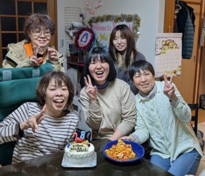 Celebrating her birthday with her host family and posing together for a commemorative photo.